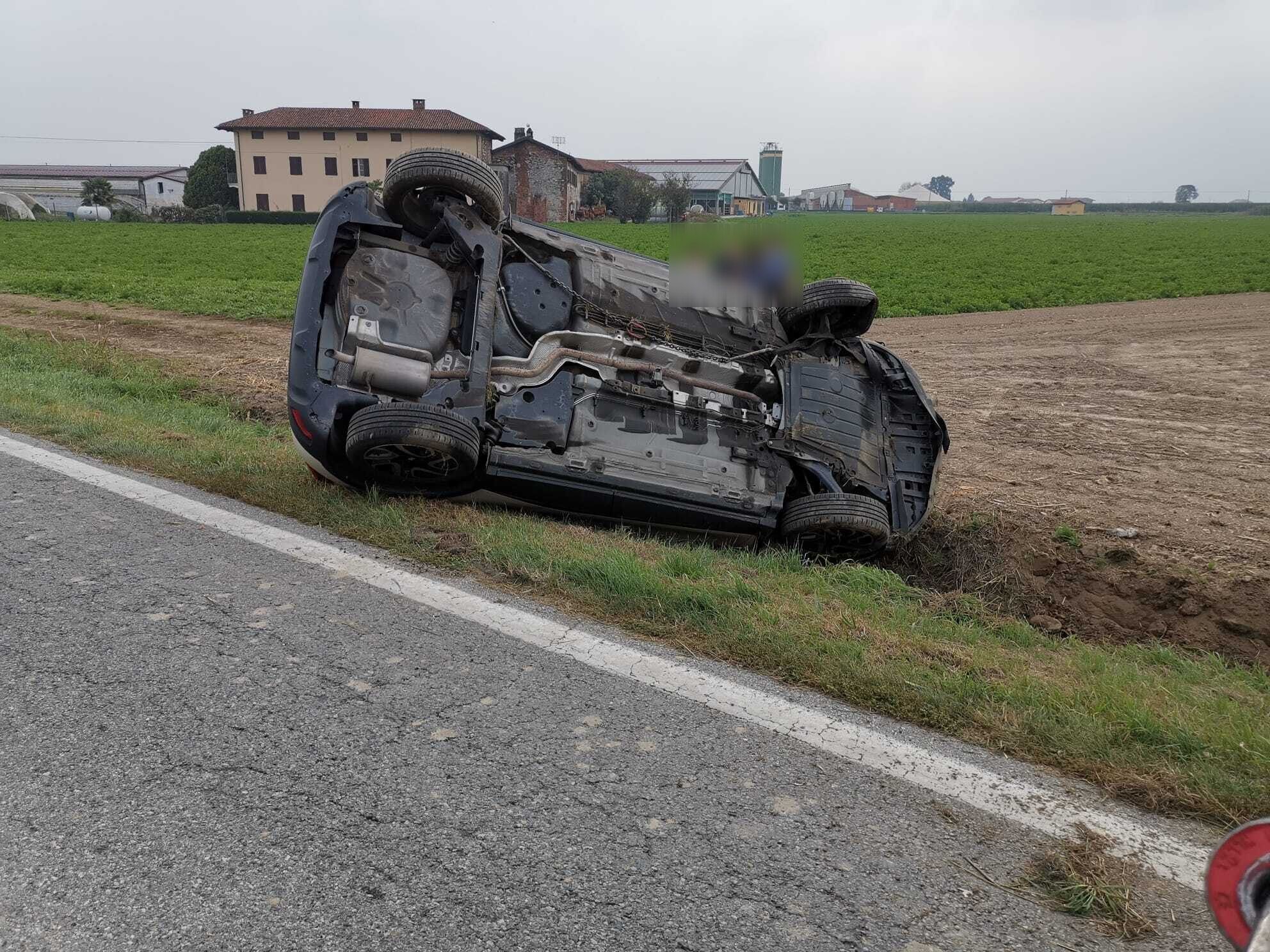 Auto ribaltata su un fianco al bordo della strada