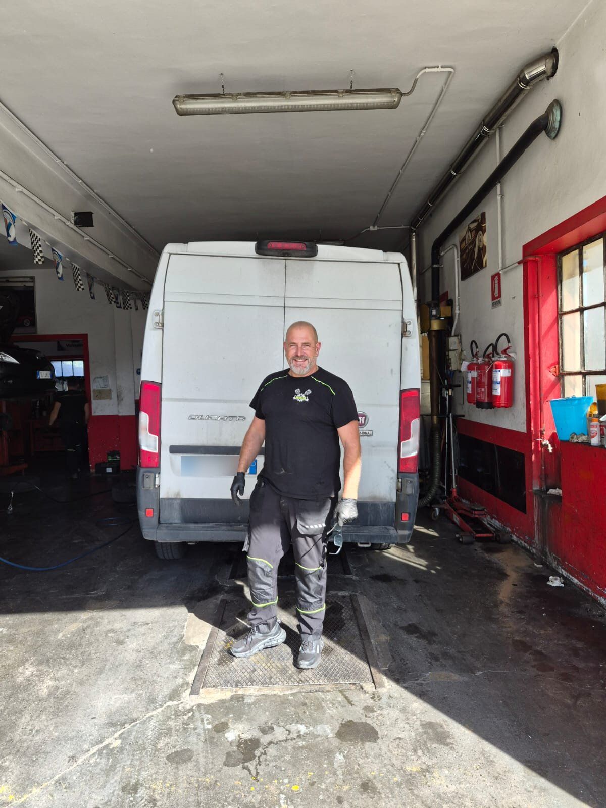 Enrico, titolare, in officina davanti a un furgone